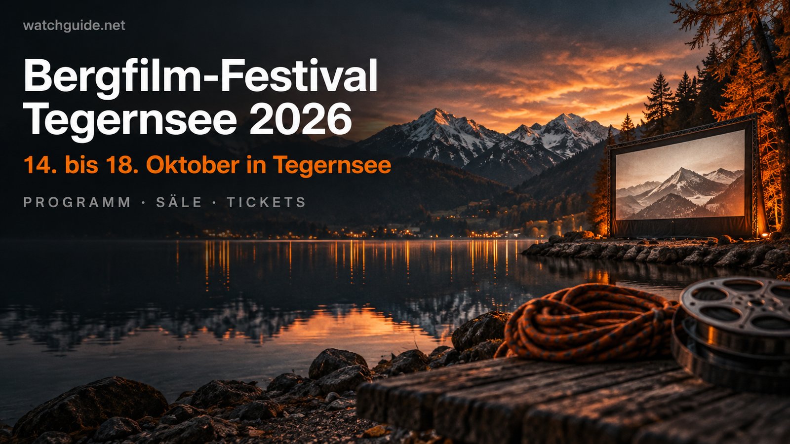 Leuchtende Kinoleinwand am Ufer eines Bergsees in der Dämmerung, schneebedeckte Gipfel spiegeln sich im Wasser, dazu der Schriftzug Bergfilm-Festival Tegernsee 2026, 14. bis 18. Oktober